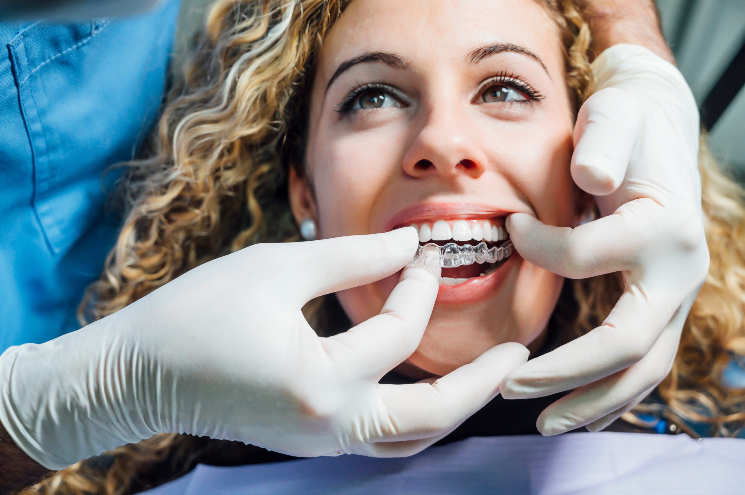 doctor puts invisalign in a patients mouth