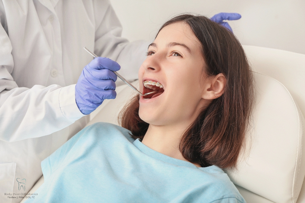 A patient lying back in a dental chair during an examination for how to fix overbite in Rocky Point, NY with a dental professional.