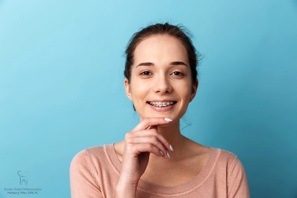 a woman with metal braces posing for the camera after understanding about how long do braces take in rocky point, ny
