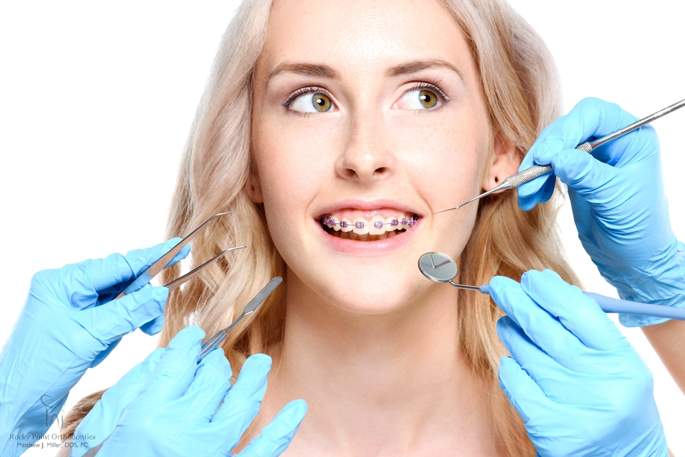 a woman having her metal braces examined after being explained about how long do braces take in rocky point, ny