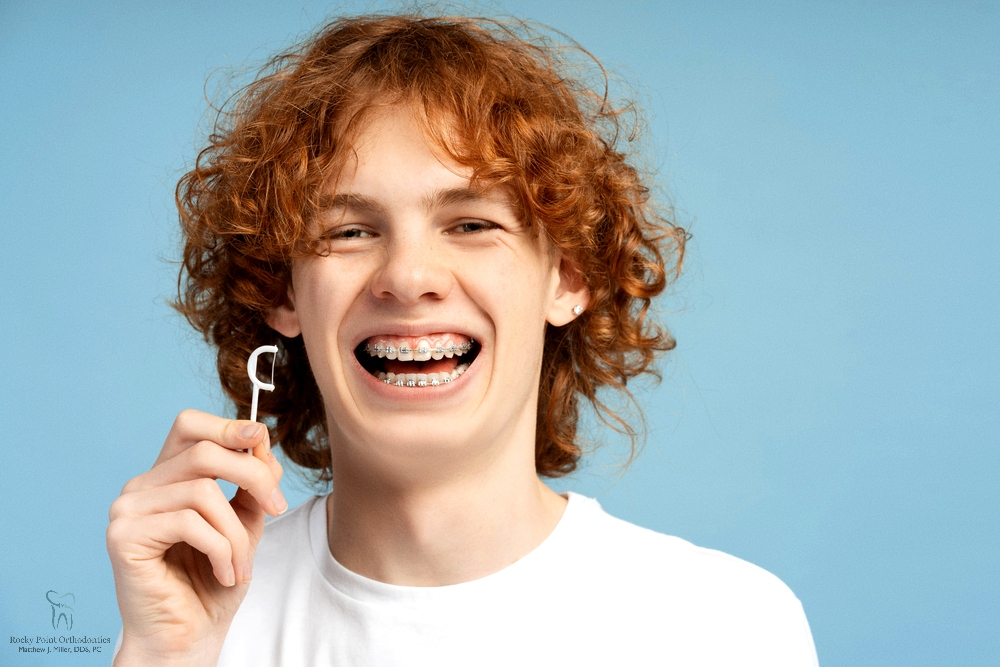 closeup image smiling teenager curly red hair metal braces - How to Floss with Braces in Rocky Point, NY