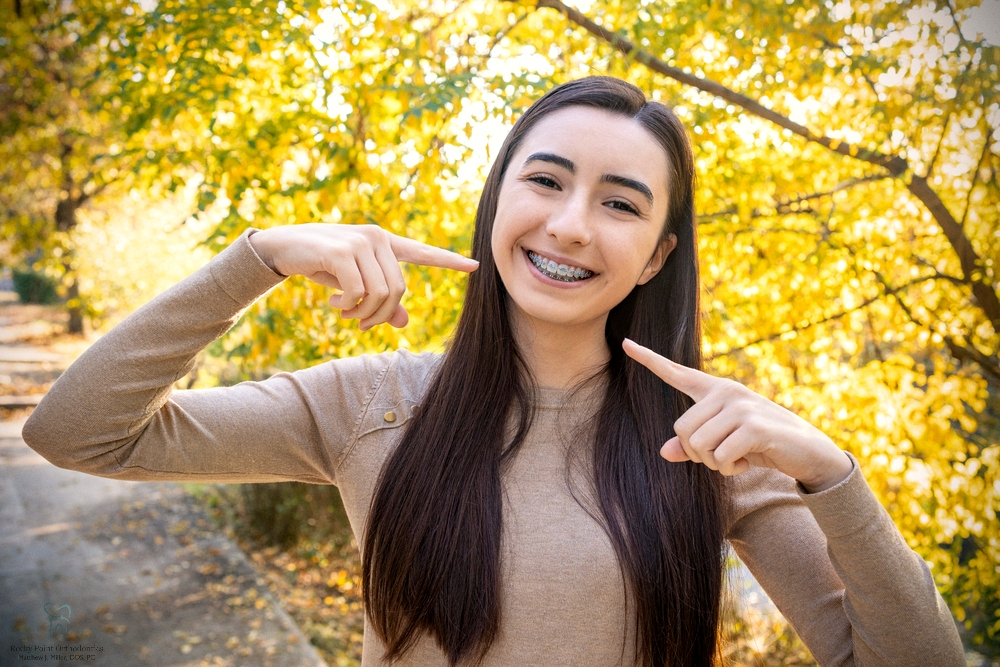 beautiful girl smiling showing metal braces teeth orthodontics dental theme - Clear Braces vs. Metal Braces in Rocky Point, NY 