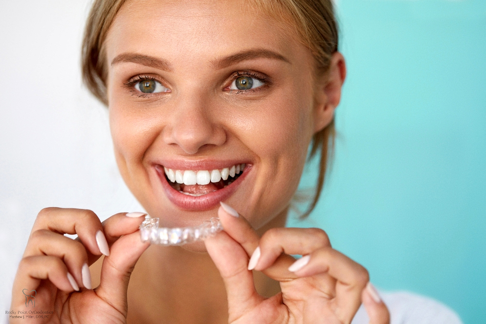 smiling woman with beautiful smile using invisalign clear aligners - How Does Invisalign Work in Rocky Point, NY 