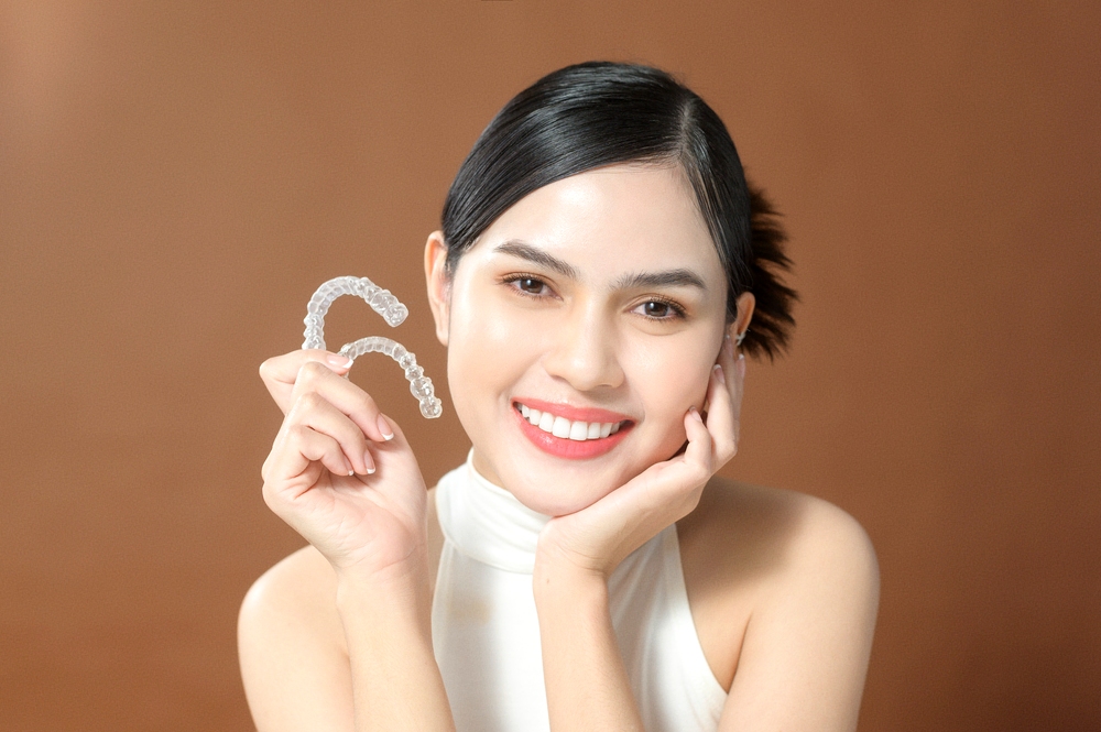 young woman beautiful teeth holding invisalign clear aligners healthy dental concept - How Does Invisalign Work in Rocky Point, NY